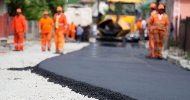 Workers putting down asphalt pavement